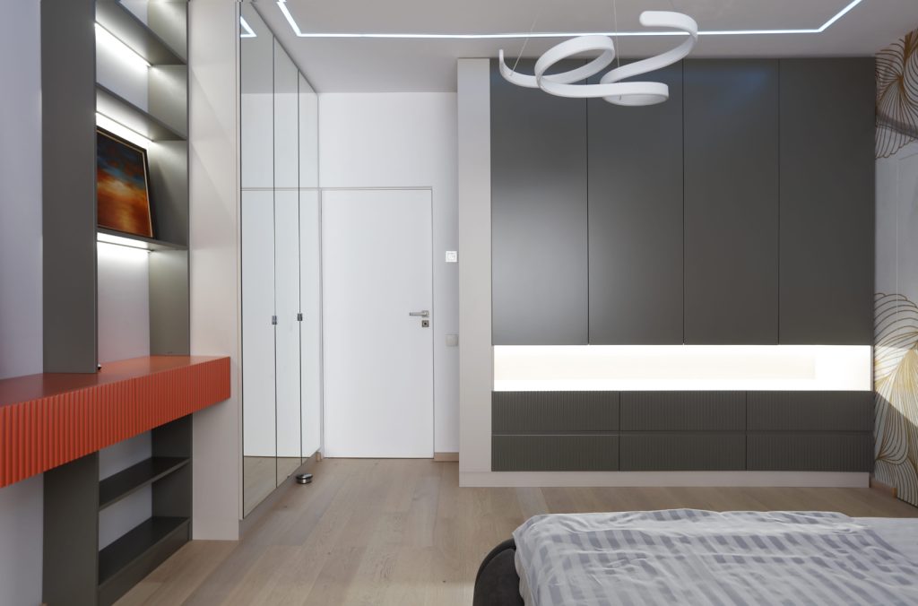 dormitor amenajat modern cu dressing gri si accente de rosu