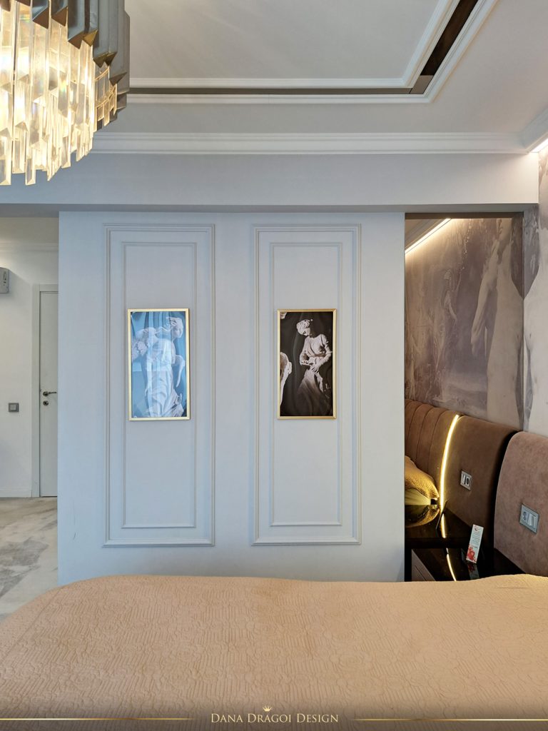 perete cu tablouri si oglinda in dormitor amenajat in stil clasic